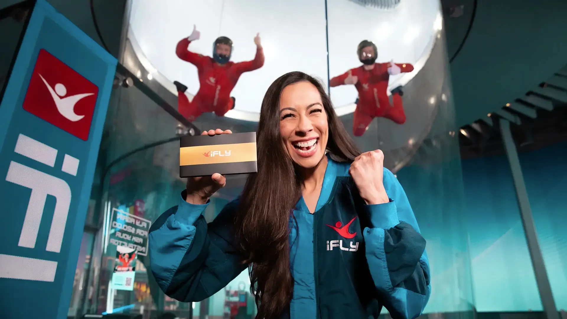 Holding an iFLY gift in front of the wind tunnel
