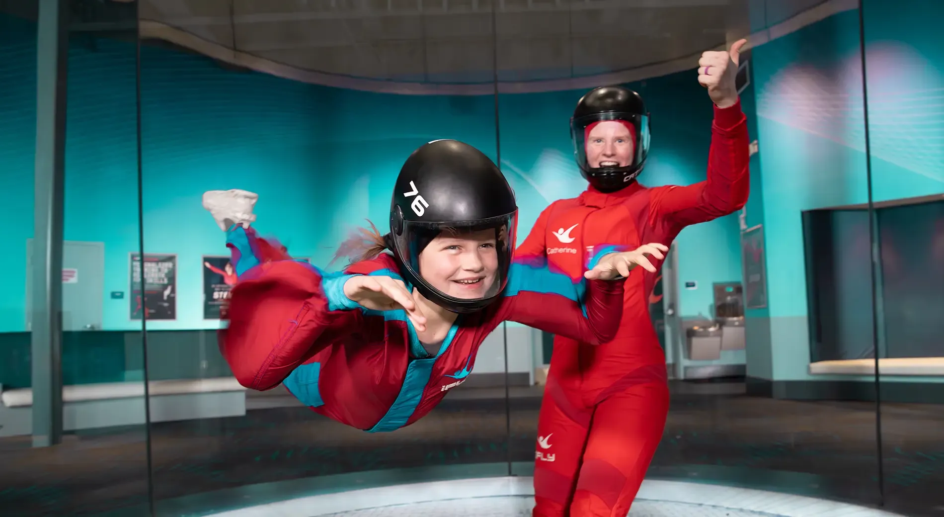 child flying in tunnel with instructor
