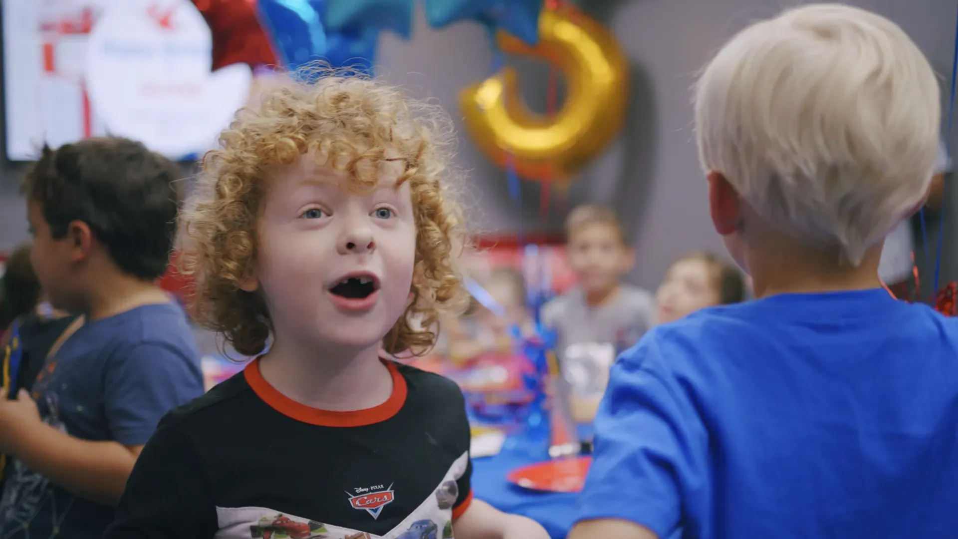 Kids watching a friend fly during an indoor skydiving birthday party at iFLY