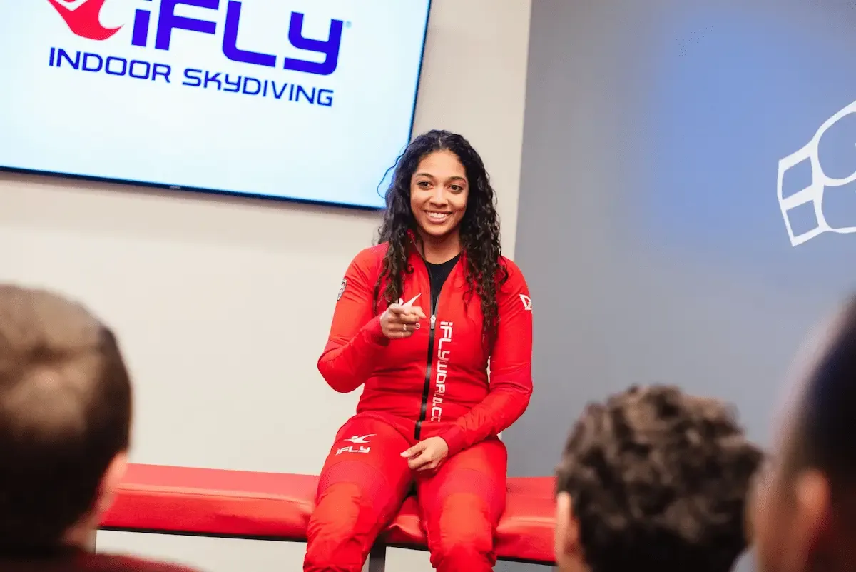 An iFLY instructor explaining the indoor skydiving experience to first-time visitors