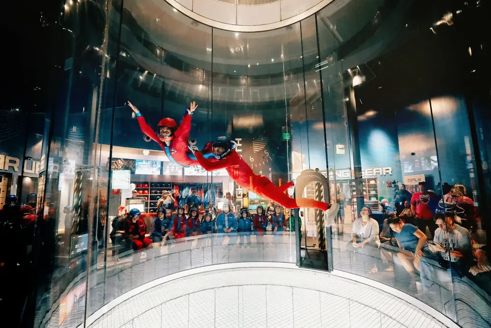 Flyer and instructor inside an iFLY indoor skydiving wind tunnel
